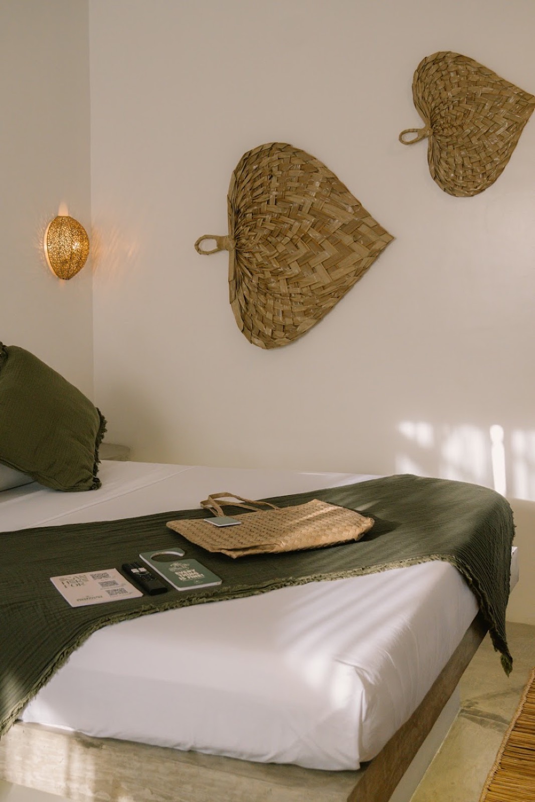 Woven native fan wall decorations and warm lighting above green textiles
